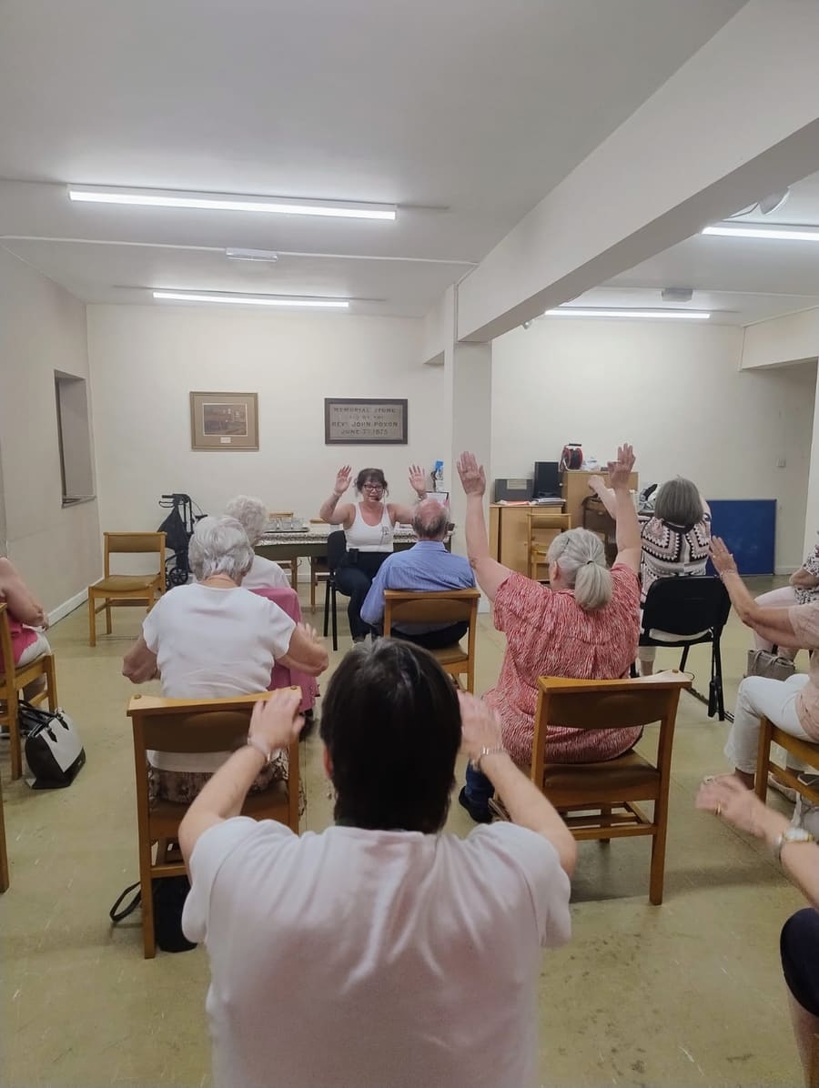 Breaston Evergreens members raising their arms during Julie's chair exercise session